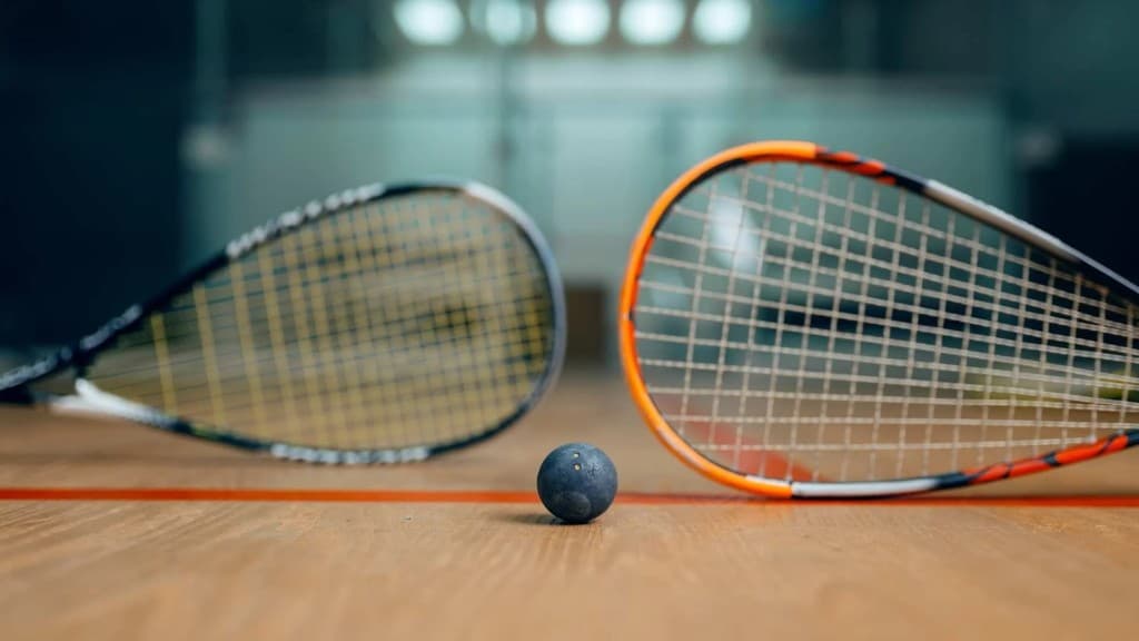 Material de squash: raquetas y pelota en pista